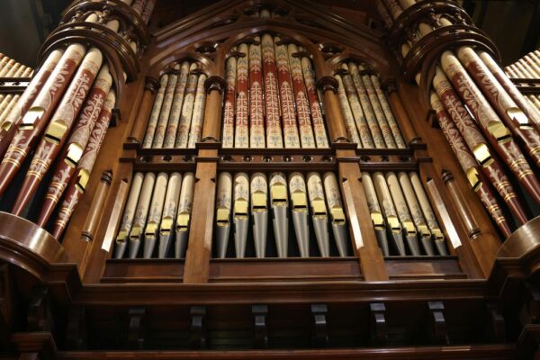 Detailansicht einer Hammond-Orgel mit bunten Pfeifen und Holzverkleidung.