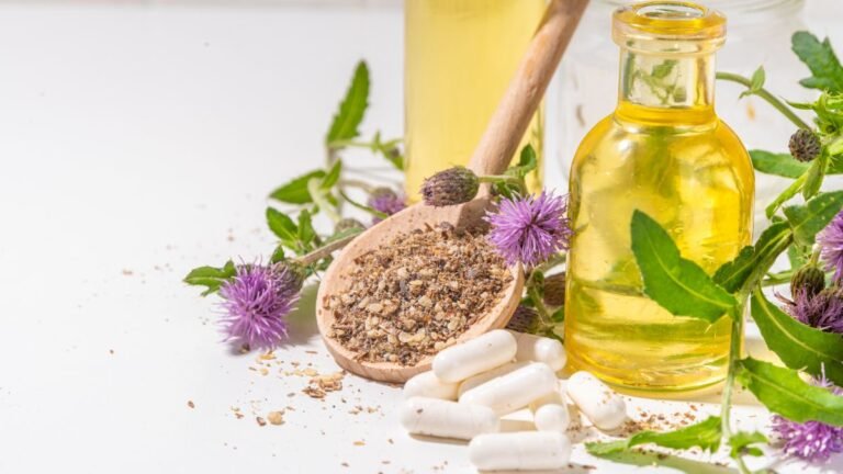 Eine Holzschaufel mit Mariendistel-Pulver, umgeben von Pflanzen und Ölen.