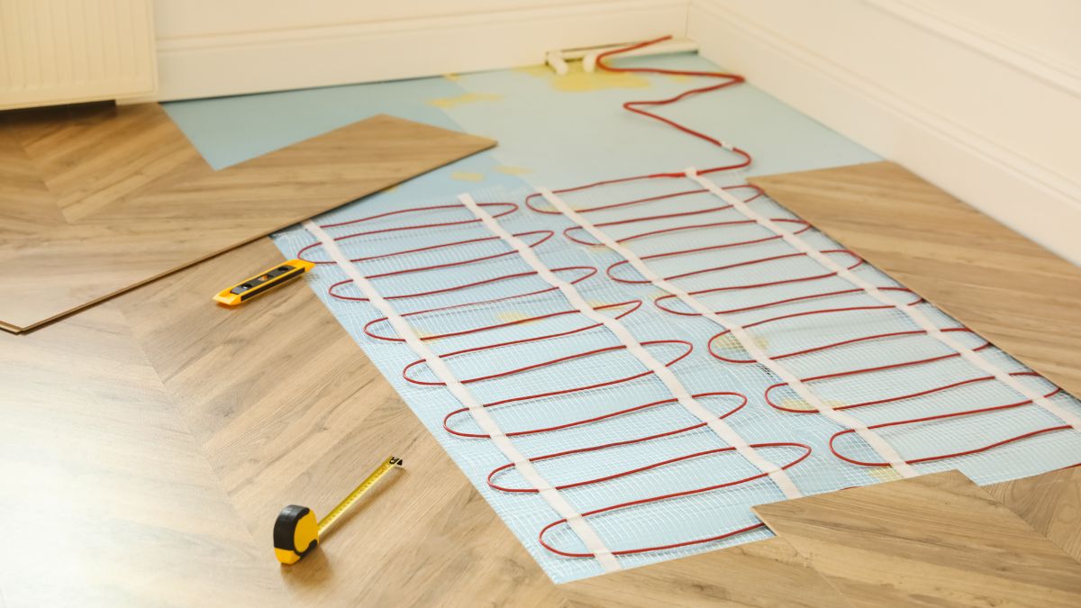 Ein Fußbodenheizungs-System mit roten Rohren auf einem Holzfußboden.