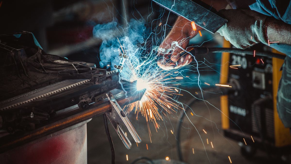 Ein Handwerker führt AWI-Schweißen durch, Funken sprühen und Rauch entsteht.