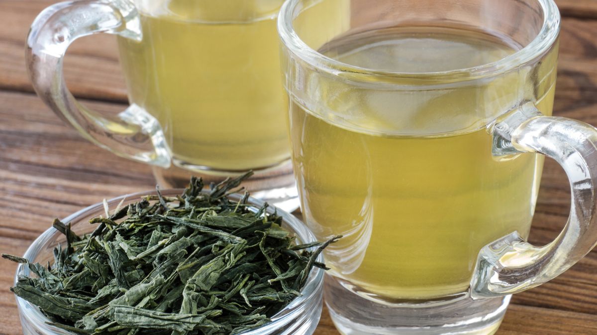 Zwei Gläser Sencha-Grüntee neben einer Schale mit losem Tee.