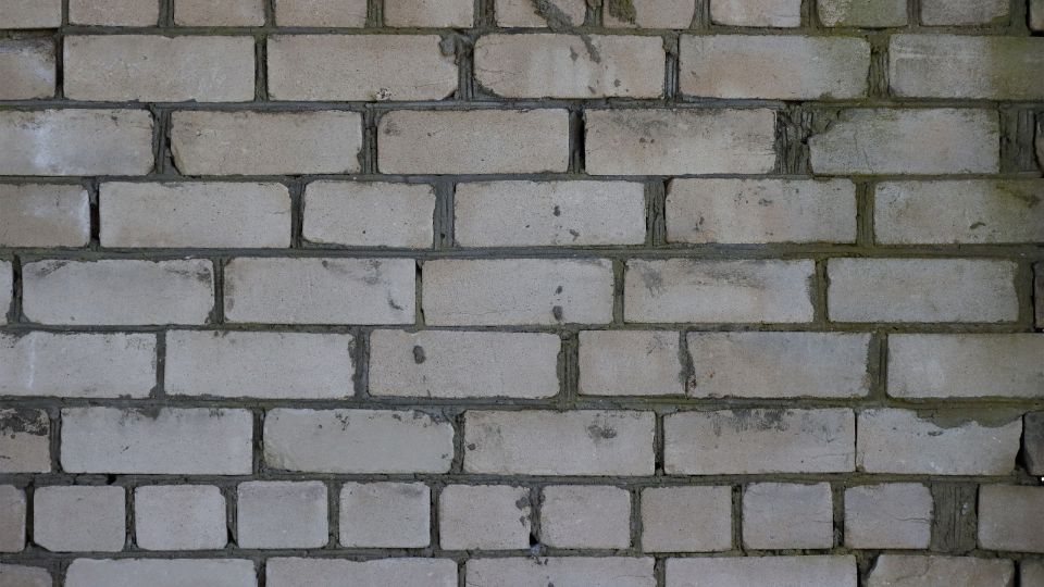 Eine Wand aus Silikatsteinen mit unregelmäßigen Fugen und Oberflächen.