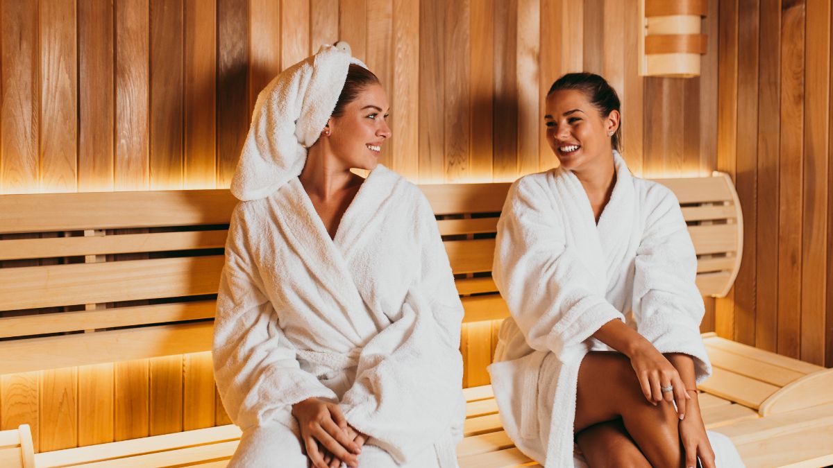 Zwei Frauen in Bademänteln entspannen in einer Infrarotsauna.