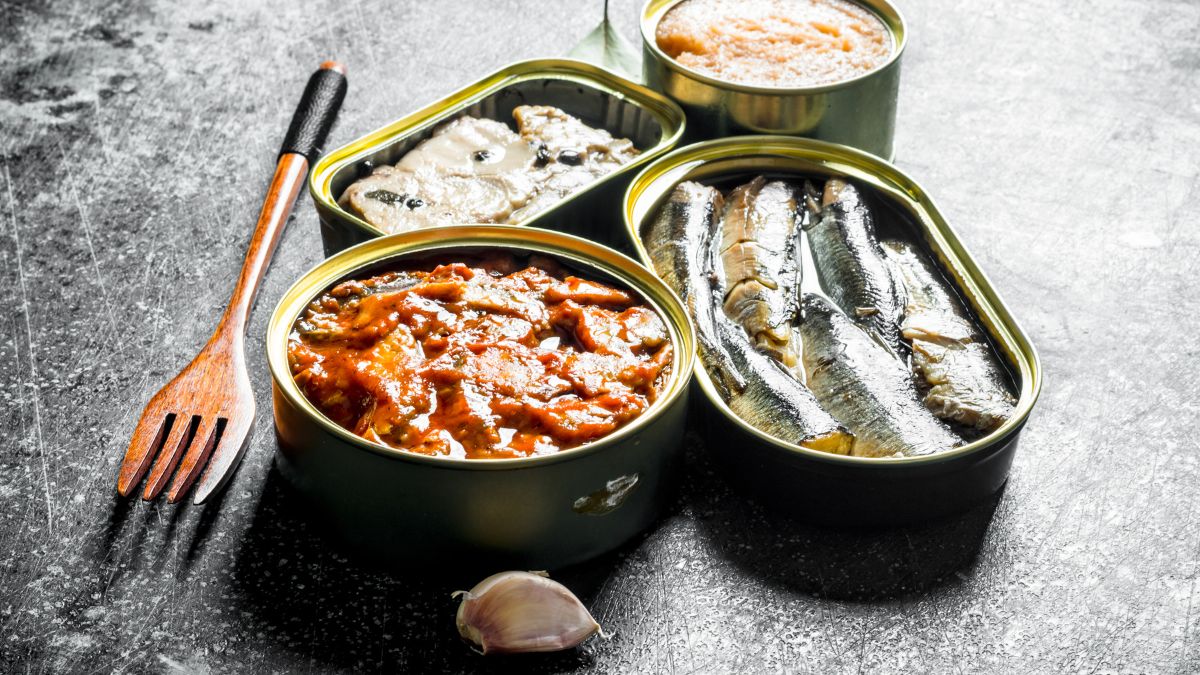 Eine Auswahl an Konserven mit Fisch und Meeresfrüchten auf einem Tisch.