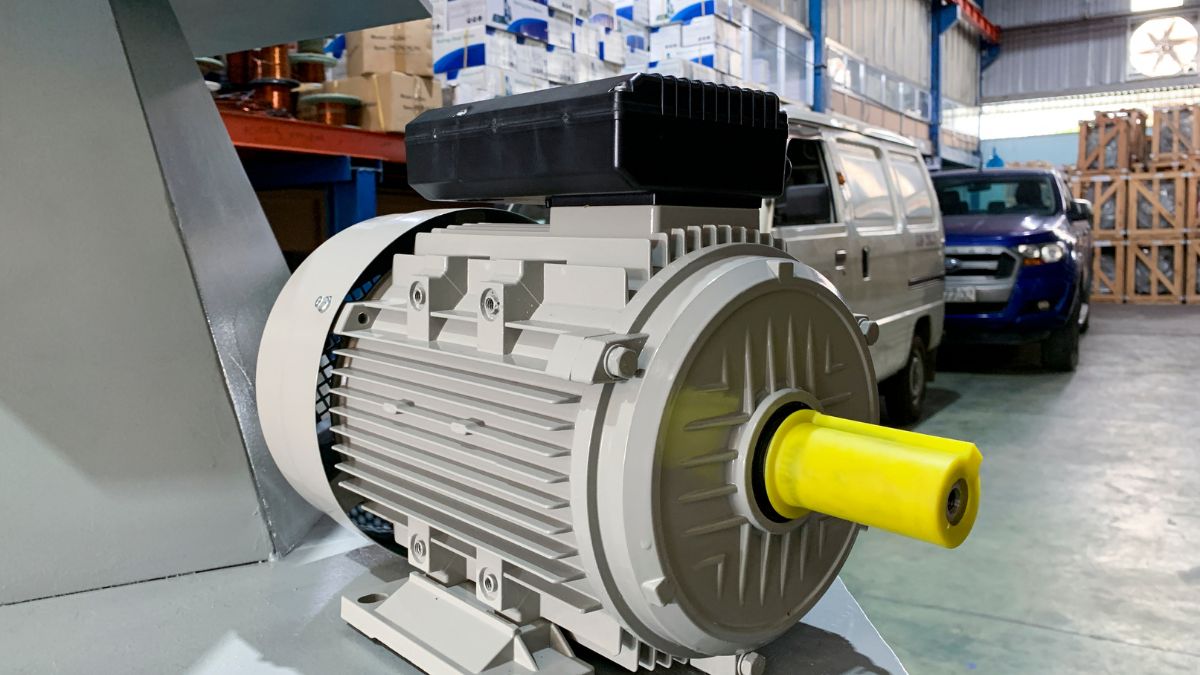 Ein Elektromotor mit gelbem Anschluss in einer Lagerumgebung.