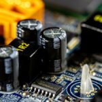 Nahaufnahme von Kondensatoren auf einer Leiterplatte mit verschiedenen Bauteilen.