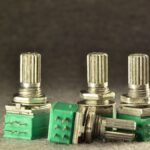 Drei Potentiometer mit metallischen Drehknöpfen und grünen Gehäusen.