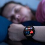 Eine schlafende Person mit einer Smartwatch, die den Puls anzeigt.