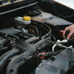 Ein Mechaniker arbeitet am Motor eines Autos, zeigt die Technik des Otto-Motors.