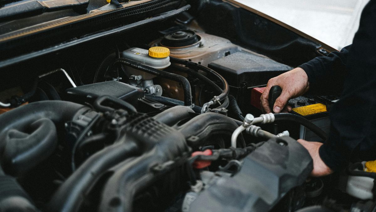 Ein Mechaniker arbeitet am Motor eines Autos, zeigt die Technik des Otto-Motors.
