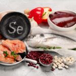 Eine Auswahl an selenreichen Lebensmitteln wie Fisch, Nüsse und Gemüse.