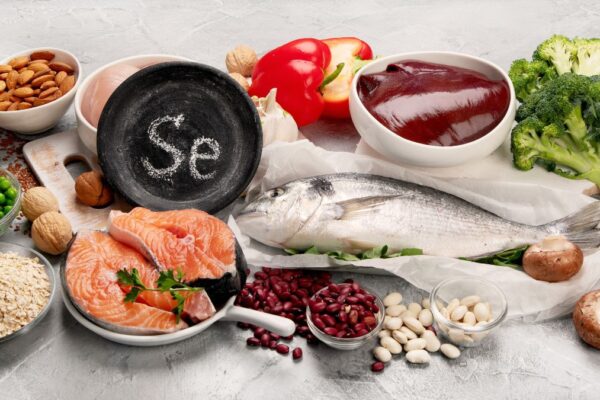 Eine Auswahl an selenreichen Lebensmitteln wie Fisch, Nüsse und Gemüse.