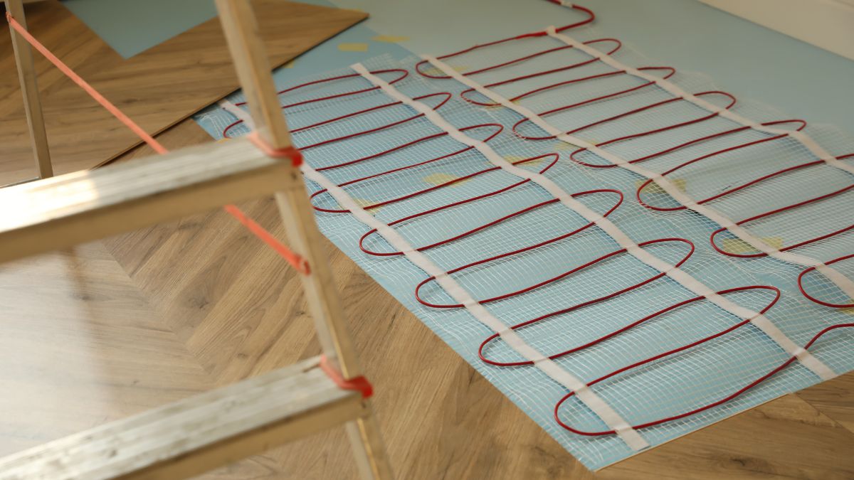 Elektrische Fußbodenheizung: Risiken, Nachteile und worauf du achten solltest Installation einer elektrischen Fußbodenheizung mit roten Kabeln auf einem Untergrund.